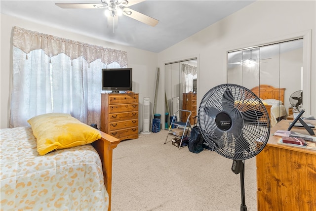 bedroom with multiple closets, carpet, lofted ceiling, and a ceiling fan