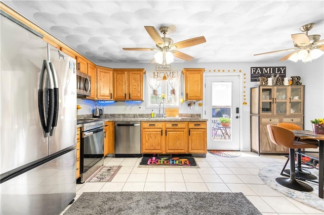 151 Bend St S Unit 2, Pawtucket, RI 02860 - kitchen featuring stainless steel appliances, a ceiling fan, a sink, and brown cabinetry