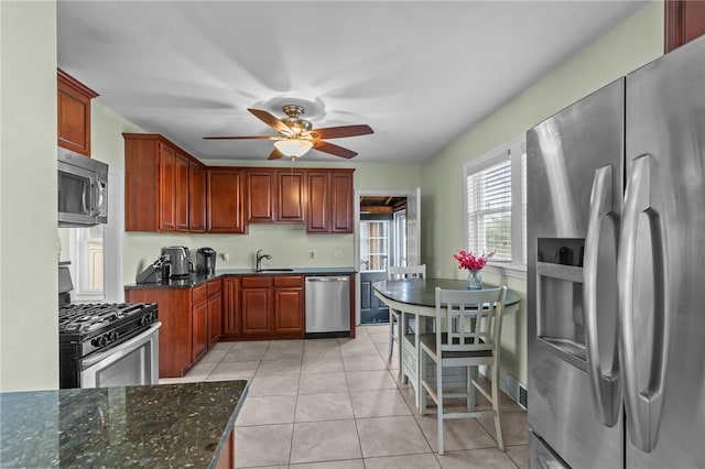 95 Vincent Ave, North Providence, RI 02904 - kitchen with stainless steel appliances, a ceiling fan, a sink, light tile patterned floors, and dark stone counters