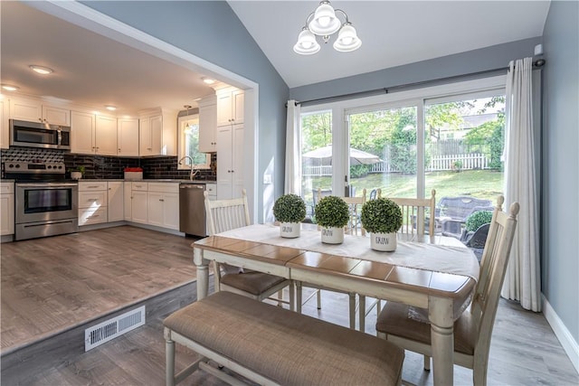33 Perennial Dr, Cranston, RI 02920 - dining room with wood finished floors, vaulted ceiling, baseboards, and a chandelier