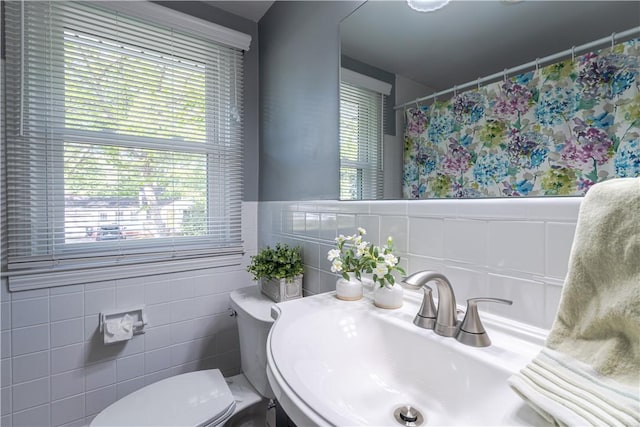 33 Perennial Dr, Cranston, RI 02920 - bathroom featuring a sink, toilet, tile walls, a shower with shower curtain, and wainscoting