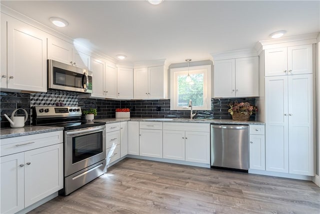 33 Perennial Dr, Cranston, RI 02920 - kitchen featuring appliances with stainless steel finishes, a sink, white cabinetry, tasteful backsplash, and light stone countertops