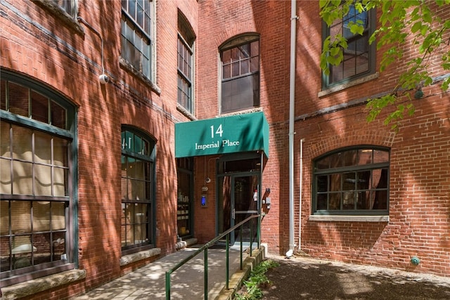 doorway to property featuring brick siding