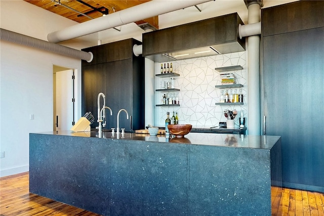 indoor wet bar with light wood-type flooring, tasteful backsplash, baseboards, and wooden ceiling