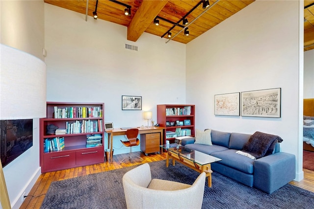 living area featuring wooden ceiling, rail lighting, wood-type flooring, an office area, and beamed ceiling