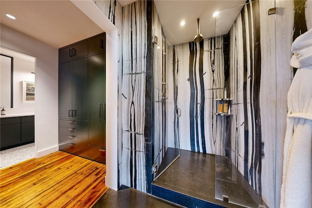 bathroom featuring walk in shower, vanity, and recessed lighting