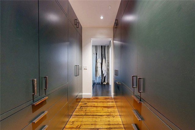 hallway featuring wood finished floors, recessed lighting, and baseboards