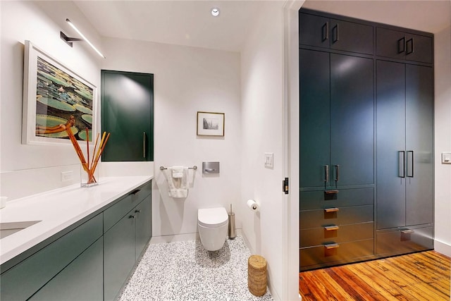 bathroom with toilet, vanity, and baseboards