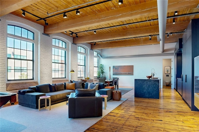 community lobby with wood ceiling, beam ceiling, and brick wall