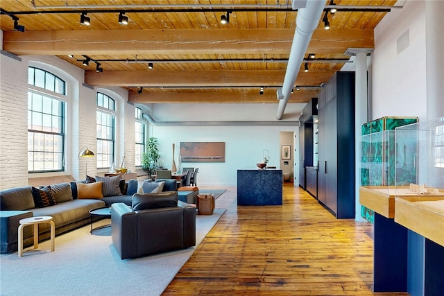 common area featuring wood ceiling, beam ceiling, and brick wall