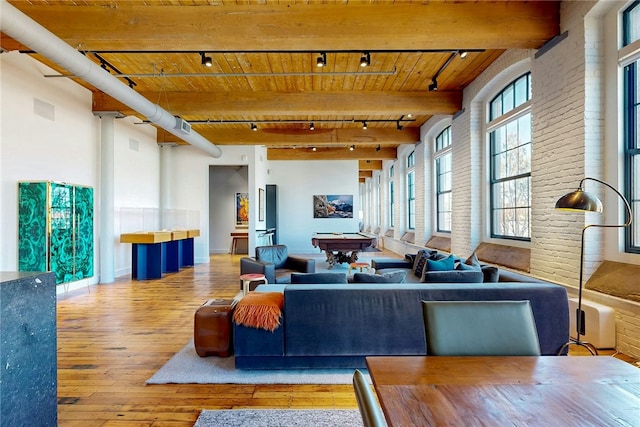 building lobby with wood ceiling, brick wall, and beam ceiling