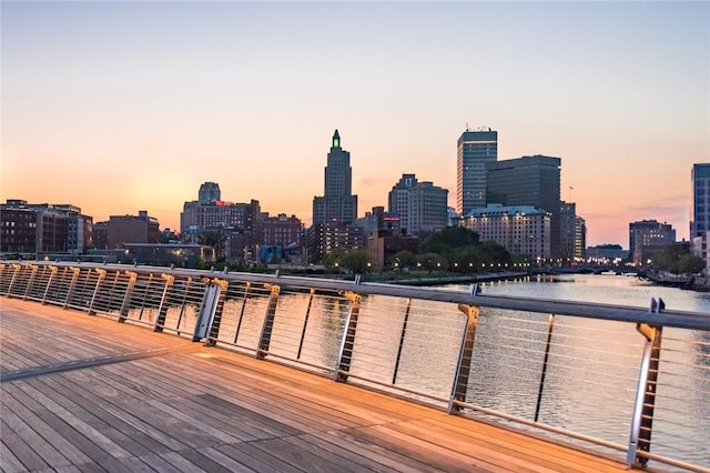 deck at dusk featuring a view of skyline and a water view