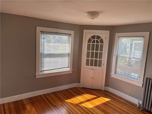 24 George St, Westerly, RI 02891 - doorway to outside featuring radiator, baseboards, and wood finished floors