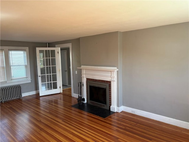 24 George St, Westerly, RI 02891 - unfurnished living room with radiator heating unit, hardwood / wood-style flooring, a fireplace, and baseboards