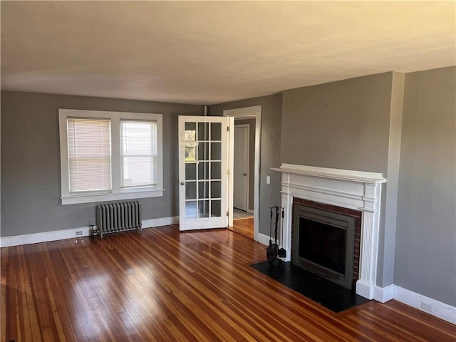 24 George St, Westerly, RI 02891 - unfurnished living room featuring radiator heating unit, baseboards, a fireplace with flush hearth, and hardwood / wood-style floors