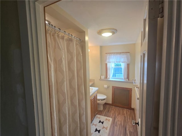full bathroom featuring vanity, toilet, wood finished floors, baseboards, and a shower with curtain