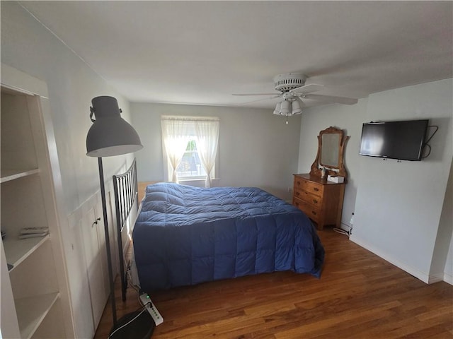 bedroom with wood finished floors, ceiling fan, and baseboards