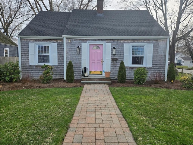 cape cod home with a chimney and a shingled roof