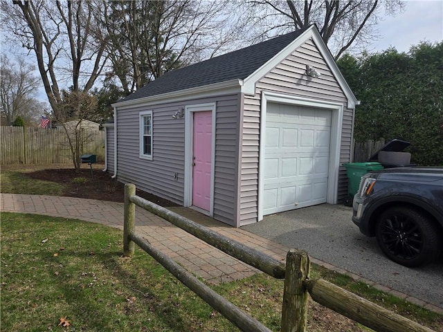 detached garage featuring fence