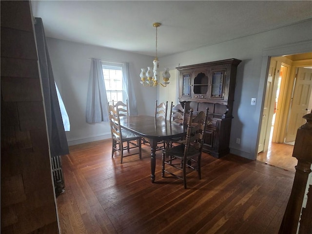dining space featuring a chandelier, dark wood-style floors, and baseboards
