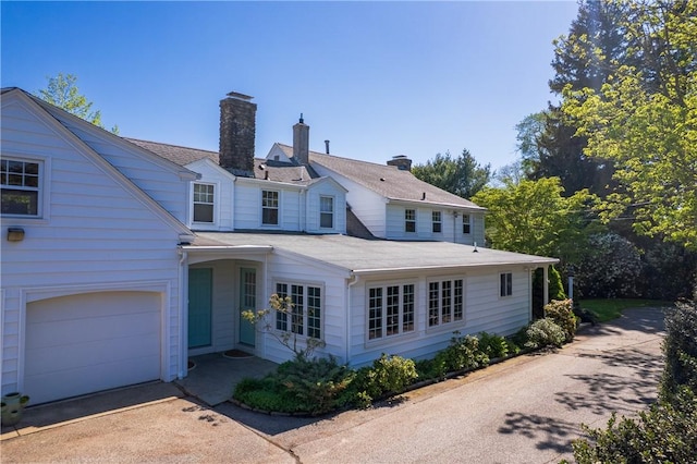 2 Cherry Ln, Bristol, RI 02809 - back of property with a chimney, concrete driveway, and a garage