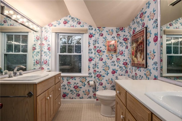 2 Cherry Ln, Bristol, RI 02809 - bathroom featuring wallpapered walls, baseboards, lofted ceiling, tile patterned floors, and two vanities