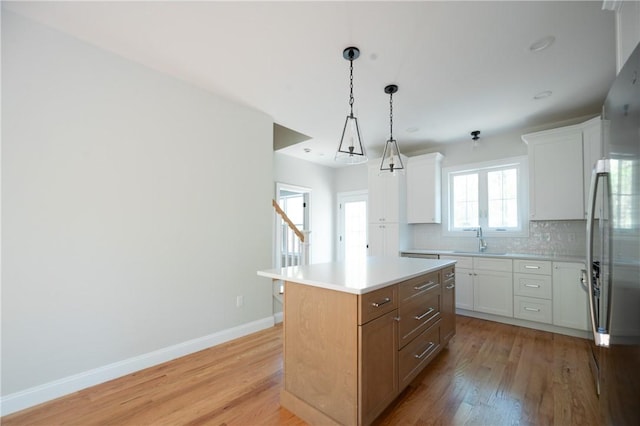 145 Wolf Rock Rd, Exeter, RI 02822 - kitchen featuring a sink, light wood-type flooring, backsplash, and baseboards