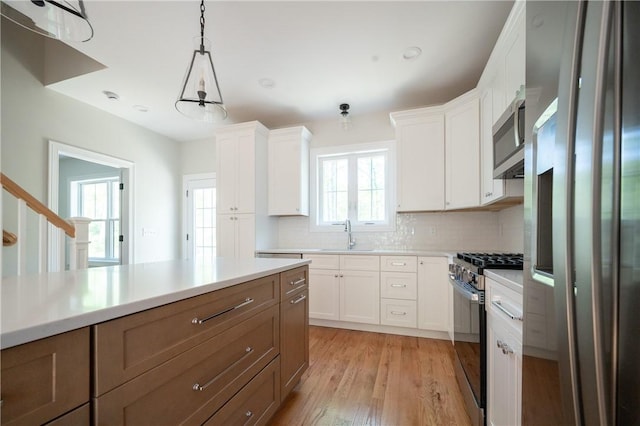 145 Wolf Rock Rd, Exeter, RI 02822 - kitchen with appliances with stainless steel finishes, backsplash, a sink, and light wood-type flooring