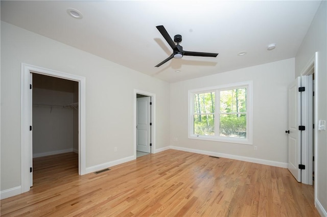 145 Wolf Rock Rd, Exeter, RI 02822 - unfurnished bedroom with light wood-style floors, baseboards, a spacious closet, and a ceiling fan