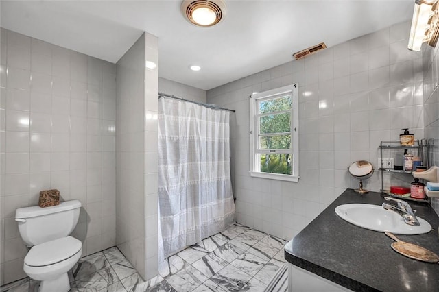 full bathroom with tile walls, a tile shower, toilet, vanity, and marble finish flooring