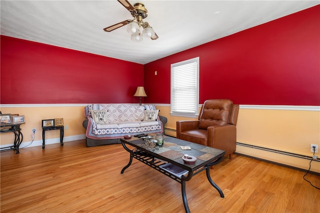 living area with a baseboard radiator, wood finished floors, and a ceiling fan