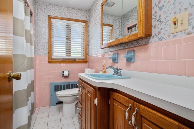 bathroom with radiator heating unit, wallpapered walls, tile patterned floors, toilet, and a wainscoted wall