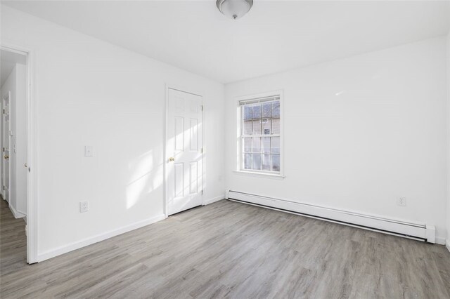 38 Brook St, Central Falls, RI 02863 - unfurnished bedroom featuring a baseboard radiator, wood finished floors, and baseboards