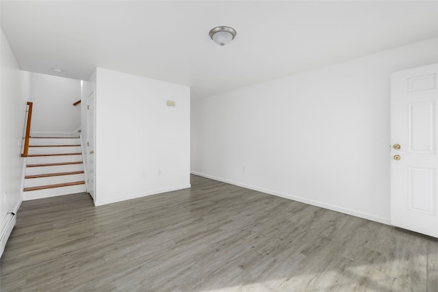 38 Brook St, Central Falls, RI 02863 - empty room featuring wood finished floors, stairway, baseboards, and baseboard heating