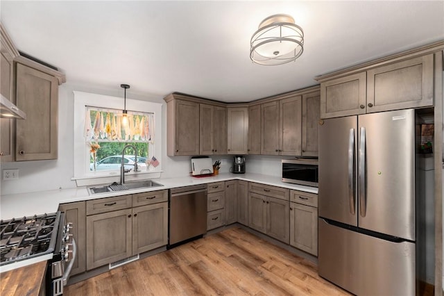 795 S Main St, Burrillville, RI 02859 - kitchen with appliances with stainless steel finishes, a sink, light wood-style floors, hanging light fixtures, and light countertops