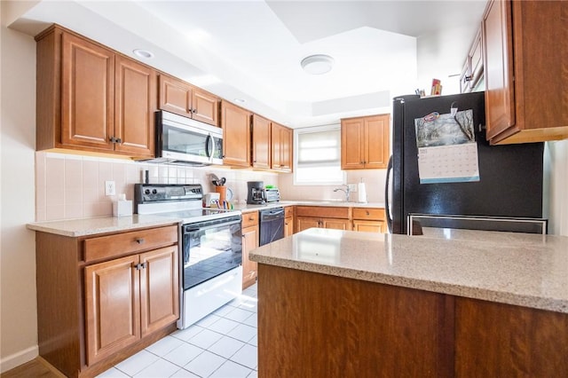 3399 Post Rd Unit 7, Warwick, RI 02886 - kitchen featuring black appliances, a peninsula, a sink, and light stone counters