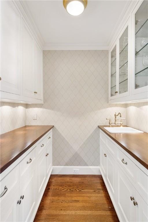125 Grotto Ave, Providence, RI 02906 - kitchen featuring a sink, dark countertops, dark wood-type flooring, glass insert cabinets, and ornamental molding