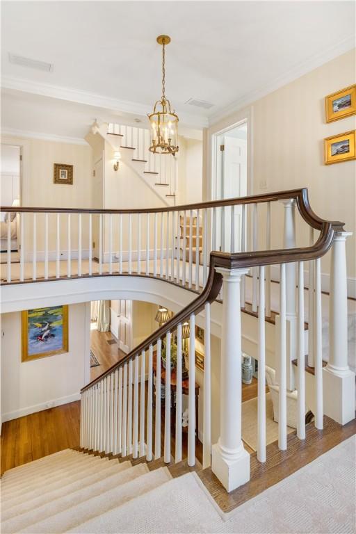 125 Grotto Ave, Providence, RI 02906 - stairs featuring ornamental molding, a chandelier, and wood finished floors