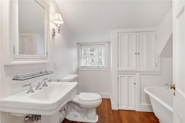 125 Grotto Ave, Providence, RI 02906 - bathroom with toilet, a soaking tub, wood finished floors, baseboards, and a sink