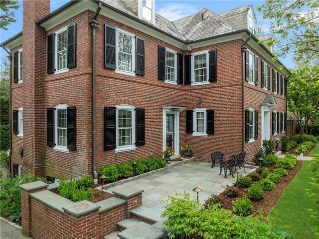 125 Grotto Ave, Providence, RI 02906 - view of side of property with brick siding and a high end roof