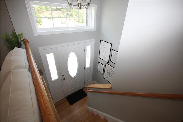 entrance foyer with a chandelier and wood finished floors