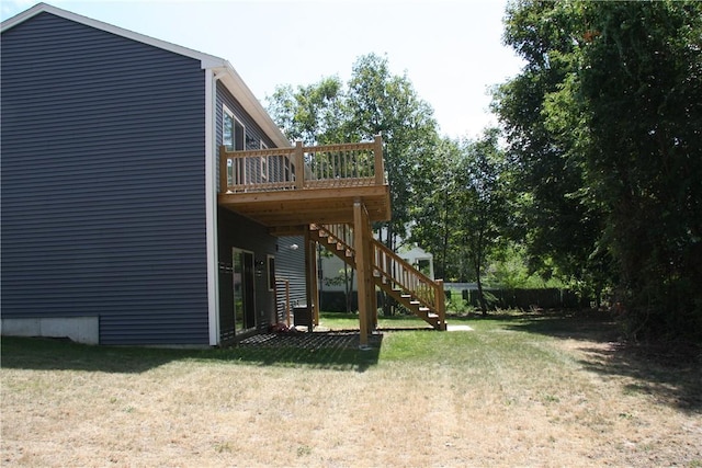 view of grassy yard featuring stairs and a deck