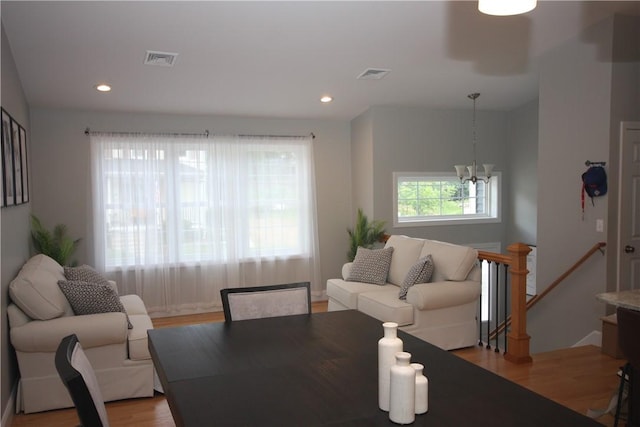 living room with a chandelier, light wood-style flooring, and recessed lighting