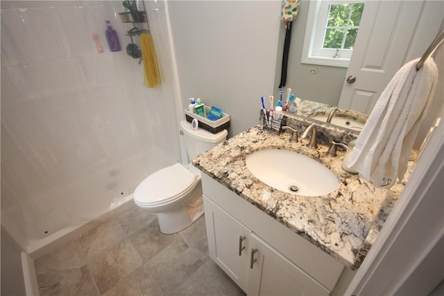 bathroom featuring a shower stall, vanity, and toilet