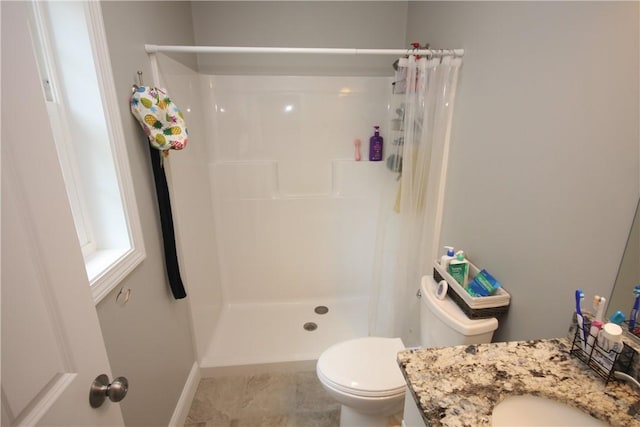 bathroom with a stall shower, toilet, baseboards, and vanity