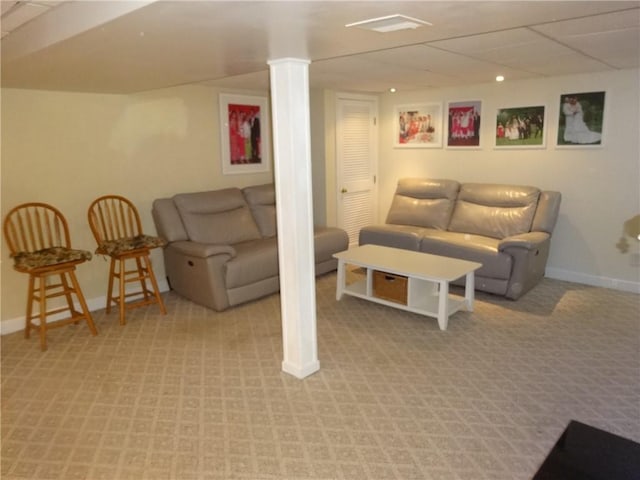living room featuring light colored carpet, baseboards, and ornate columns