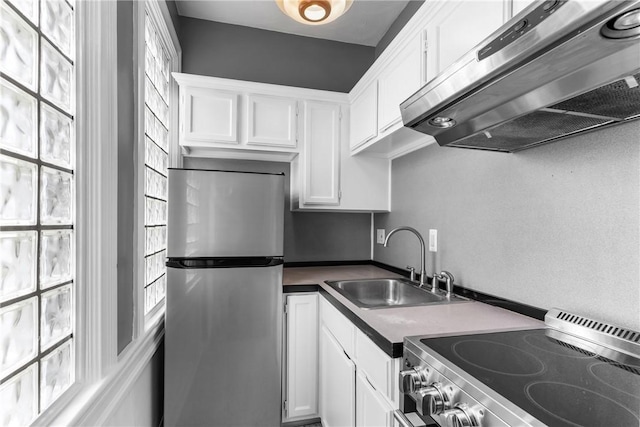 kitchen with stainless steel appliances, exhaust hood, a sink, and white cabinetry