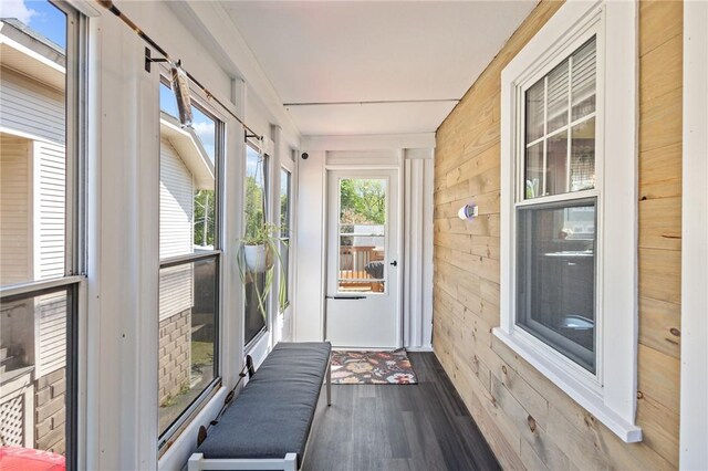 sunroom with wood walls and wood finished floors