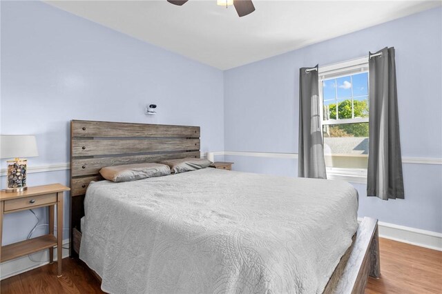 bedroom with wood finished floors, ceiling fan, and baseboards
