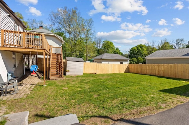 view of yard featuring a storage shed, stairs, an outbuilding, and a deck
